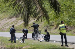 Malaysian police search suspects leaving the security cordon in Sabah.