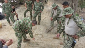 U.S. Navy Riverines discuss tactics with their Colombian counterparts using a hasty terrain model.