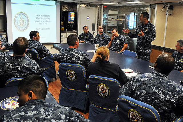 Capt. Frank Olmo, deputy commander, Naval Surface and Mine Warfighting Development Center (SMWDC), introduces SMWDC and the new career opportunities it provides junior surface warfare officers (SWOs) during a brief aboard USS Bunker Hill (DDG 52). U.S. Navy photo).