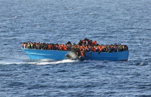 A crowded boat with migrants awaits rescue by EU NAVFOR MED. 