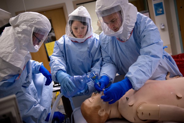 U.S. Navy Cmdr. (Dr.) Ryan Maves, Lt. Sarah Bush and Lt. j.g. Braden Spangler perform medical procedures on a simulated Ebola patient during a week-long rapid response training course. Maves, Bush and Spangler are part of a military medical response team that can rapidly respond and assist civilian medical personnel in the event of an Ebola outbreak in the United States. (U.S. Air Force photo/Master Sgt. Jeffrey Allen)