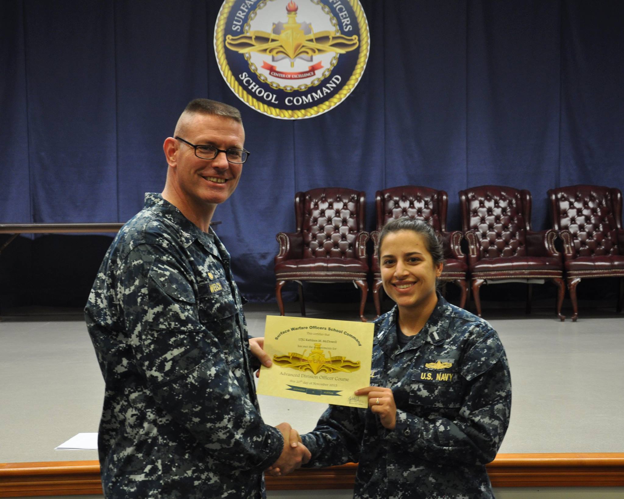 Captain Dave Welch, CO of SWOS, presents a certificate to a graduate of the Advanced Division Officer's Course (ADOC). November 2015.