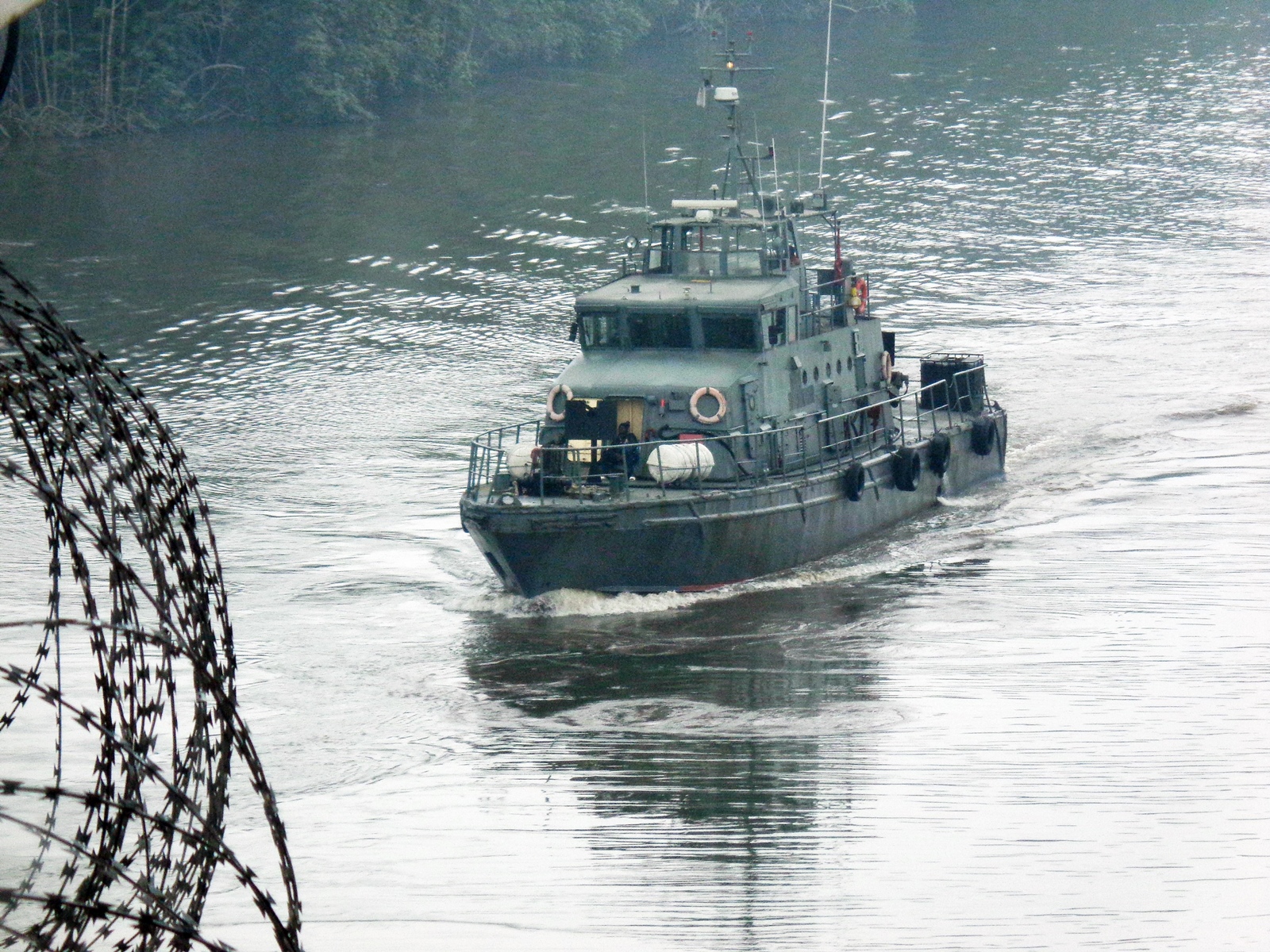 The privately contracted patrol boat NNS WARRIOR provides riverine escort to a merchant vessel in 2016. Photo: source withheld.