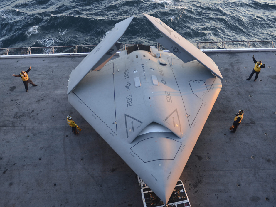 This image provided by the US navy shows sailors moving an X-47B Unmanned Combat Air System (UCAS) demonstrator onto an aircraft elevator aboard the aircraft carrier USS George H.W. Bush Tuesday, May 14, 2013. The drone was launched off the George H.W. Bush to be the first aircraft carrier to catapult launch an unmanned aircraft from its flight deck. (AP Phioto/U.S. Navy photo by Mass Communication Specialist 2nd Class Timothy Walter)