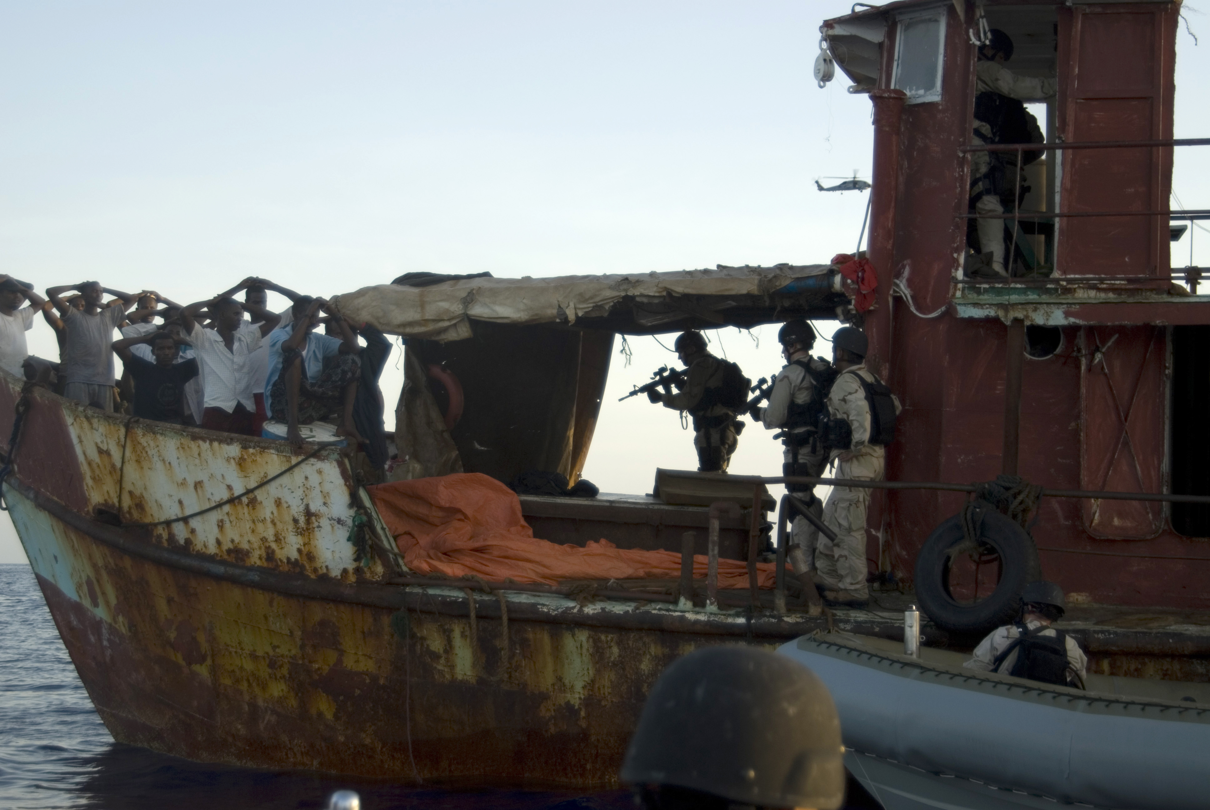 Members of a visit, board, search and seizure team assigned to USS Gettysburg (CG 64) and U.S. Coast Guard Tactical Law Enforcement Team South Detachment 409 detain suspected pirates after responding to a merchant vessel distress signal while operating in the Combined Maritime Forces area of responsibility in the Gulf of Aden May 13, 2009. The service members are conducting the operation in support of Combined Task Force 151, a multinational task force established to counter piracy operations and to actively deter, disrupt and suppress piracy in order to protect global maritime security and secure freedom of navigation for all nations. (DoD photo by Mass Communication Specialist 1st Class Eric L. Beauregard, U.S. Navy/Released)