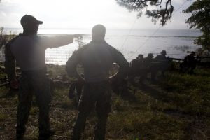 Petty Officers 3rd Class Raymond Delossantos (left) and 2nd Class Jeremy Milford (right) of Riverine Squadron 3 instruct Paraguayan Marines on establishing security after debarking riverine craft during UNITAS 2012. Credit: Cpl Tyler Thornhill, USMC