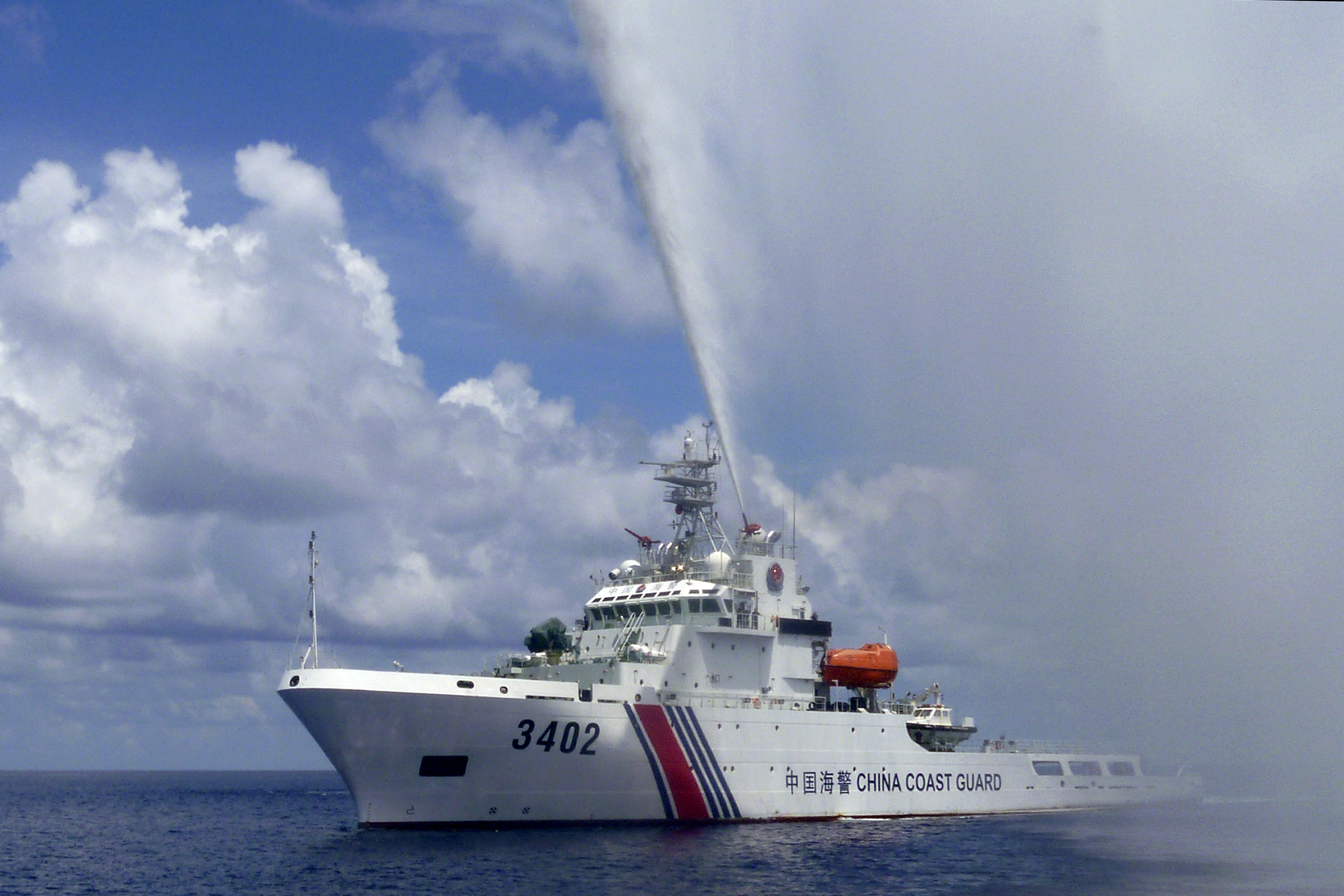In this Sept. 23, 2015, photo, provided by Filipino fisherman Renato Etac, a Chinese Coast Guard boat sprays a water cannon at Filipino fishermen near Scarborough Shoal in the South China Sea. A landmark ruling on an arbitration case filed by the Philippines that seeks to strike down China's expansive territorial claims in the South China Sea will be a test for international law and world powers. China, which demands one-on-one talks to resolve the disputes, has boycotted the case and vowed to ignore the verdict, which will be handed down Tuesday, July 12, 2016, by the U.N. tribunal in The Hague. (Renato Etac via AP)