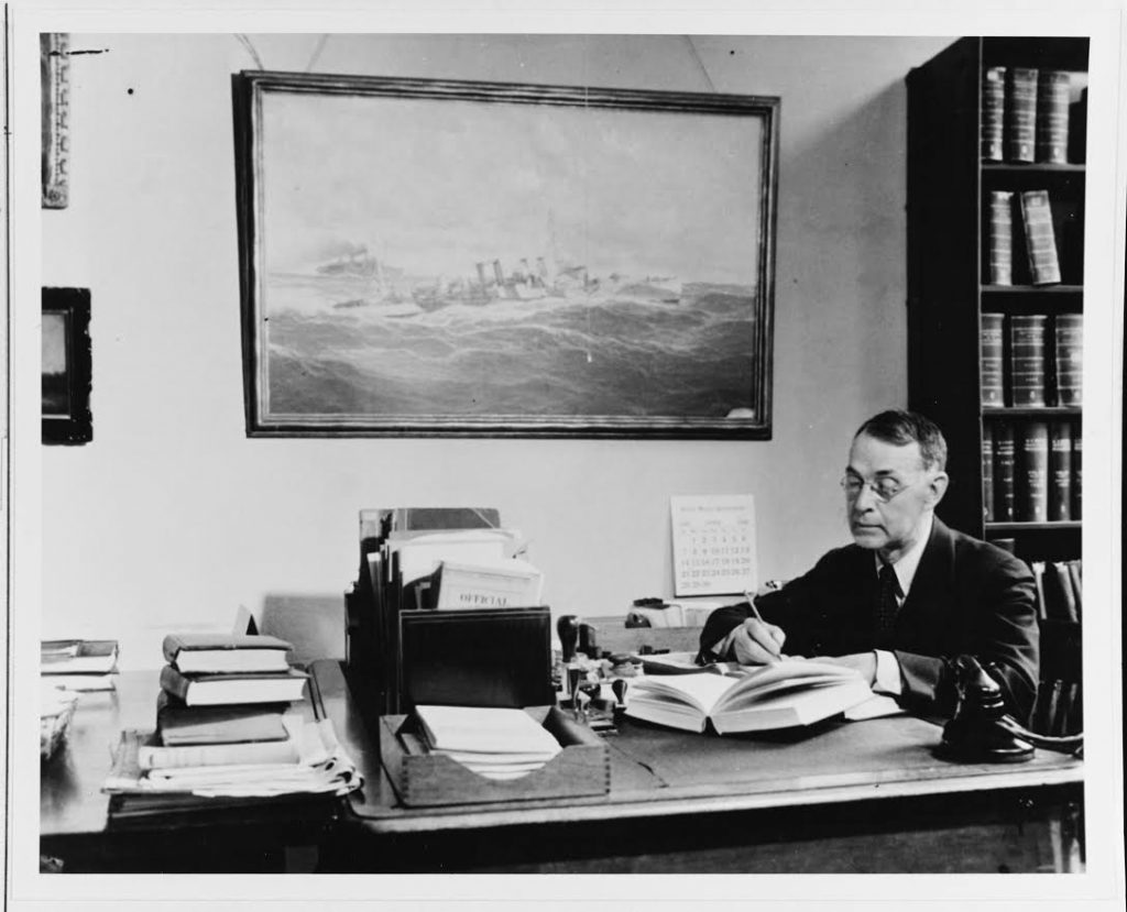 (Previously Unpublished) Dudley W. Knox requested transfer to the retired list of the U.S. Navy, seeking to broaden U.S. Navy efforts to engage the American public in understanding the influence of sea power upon history. During the 1920s and 1930s, Knox helped organize historical research and preservation efforts within the Navy Department. In this role, he also remained heavily involved with the Office of Naval Intelligence. Fusing historical research with efforts to meet contemporary challenges, Knox served as a trusted personal adviser to President Franklin. D. Roosevelt. The painting behind him is that of a destroyer escorting a convoy during the First World War. During the war, Knox was heavily involved in convoy operations.